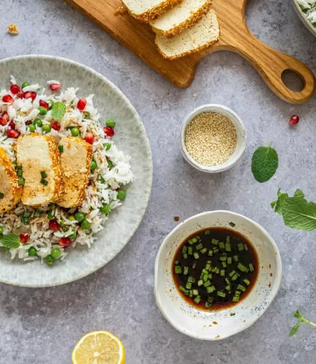 Yeşil bezelyeli pilav üzerinde susamlı tofu katsu